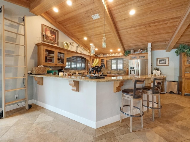 kitchen featuring stainless steel refrigerator with ice dispenser, kitchen peninsula, decorative light fixtures, wood ceiling, and a breakfast bar area