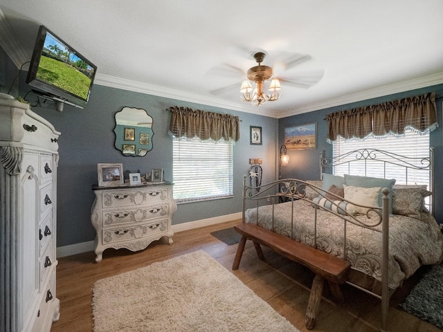 bedroom with hardwood / wood-style floors, crown molding, and multiple windows