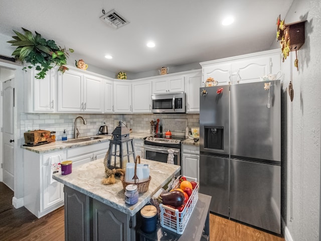 kitchen featuring a center island, white cabinetry, sink, and appliances with stainless steel finishes