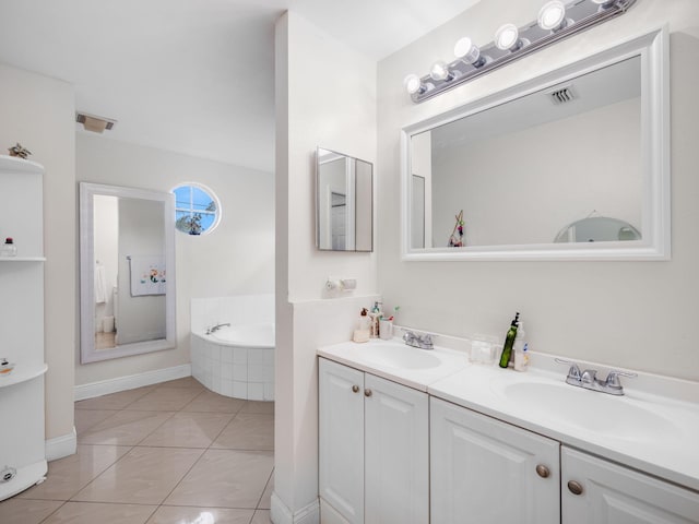 bathroom with tile patterned flooring, vanity, and tiled tub