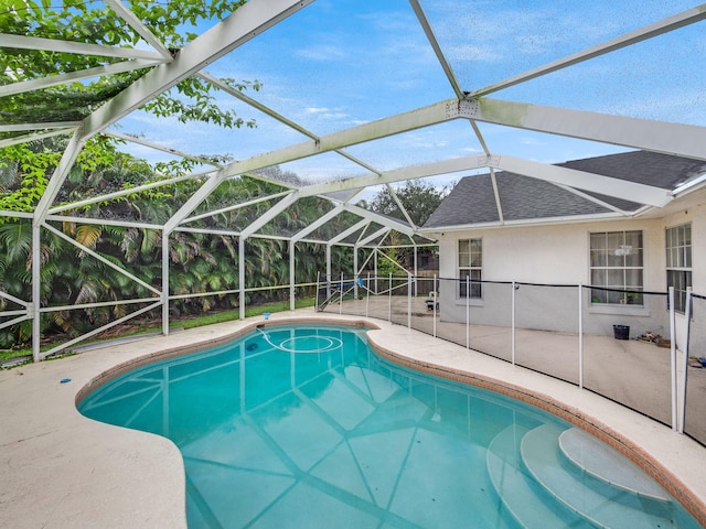 view of pool with glass enclosure and a patio