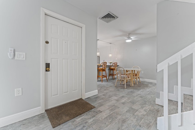 foyer with ceiling fan and light hardwood / wood-style flooring