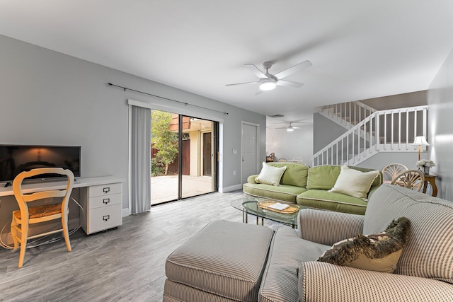 living room with light hardwood / wood-style flooring and ceiling fan