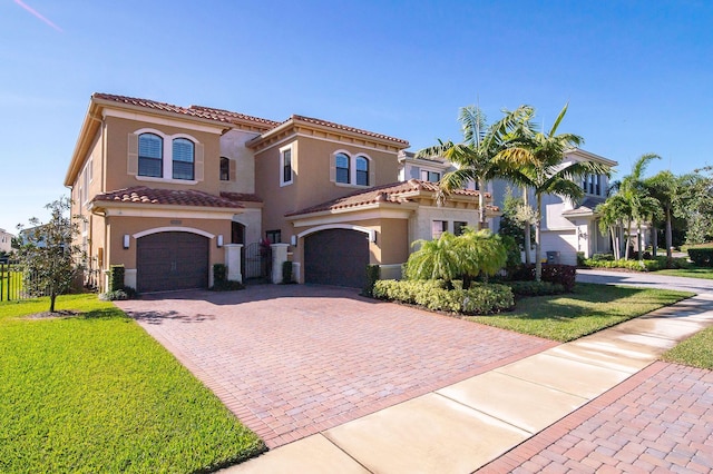 mediterranean / spanish house featuring a garage and a front lawn