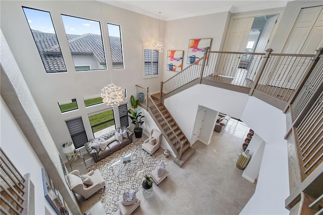 living room featuring a notable chandelier, a healthy amount of sunlight, and a high ceiling