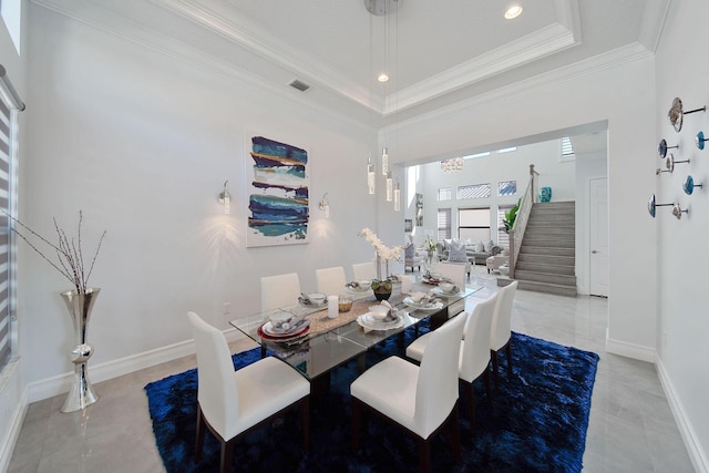 dining area featuring an inviting chandelier, crown molding, and a tray ceiling