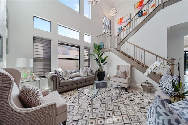 living room featuring a chandelier and a towering ceiling