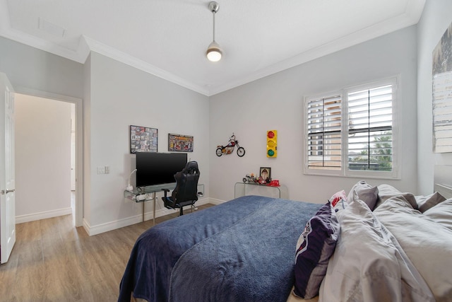 bedroom with light hardwood / wood-style floors and ornamental molding