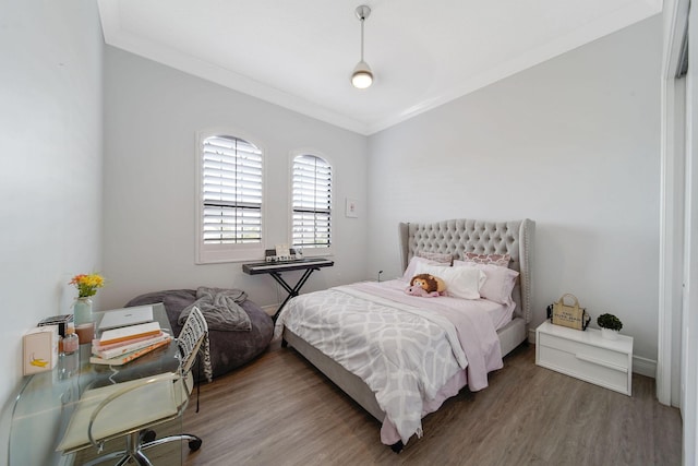 bedroom with wood-type flooring and ornamental molding