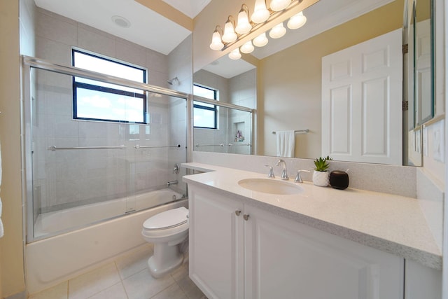 full bathroom with combined bath / shower with glass door, vanity, tile patterned flooring, and toilet