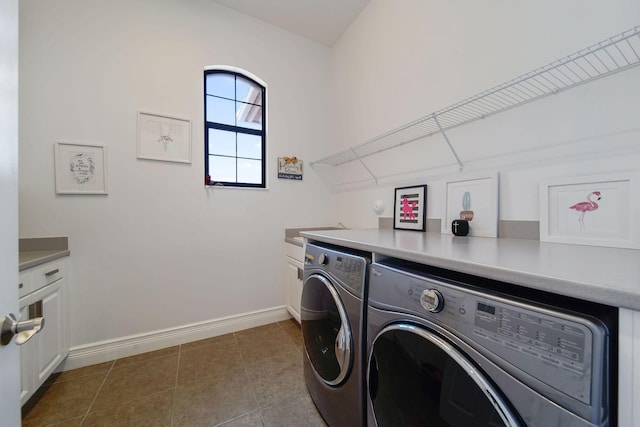 washroom with washer and clothes dryer, cabinets, and light tile patterned floors