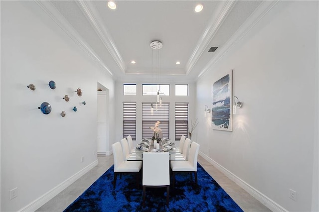 dining space with a raised ceiling and crown molding