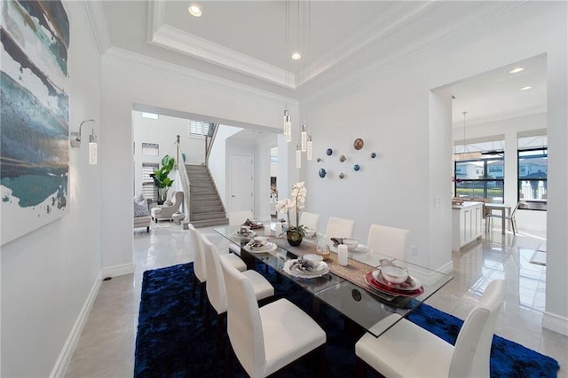 tiled dining room with a raised ceiling and crown molding