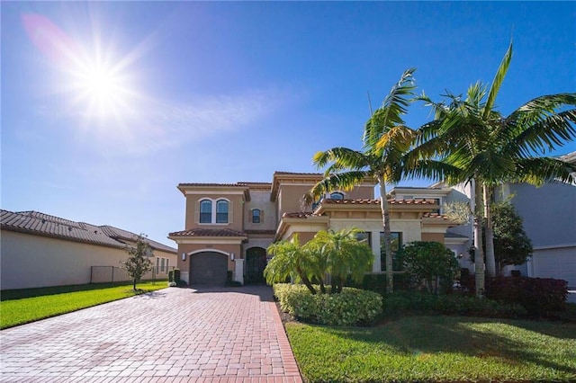 mediterranean / spanish-style home with a front yard and a garage