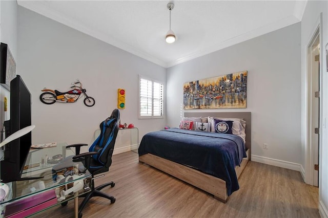 bedroom with wood-type flooring and ornamental molding