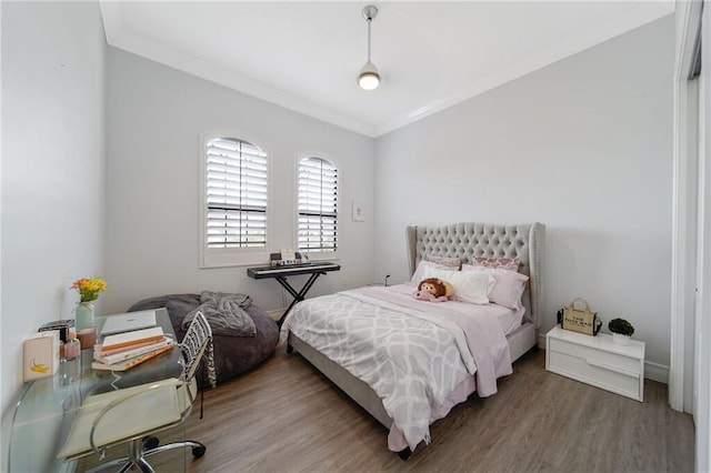 bedroom featuring wood-type flooring and crown molding