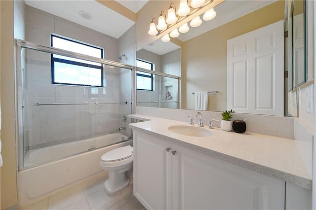 full bathroom featuring tile patterned floors, vanity, toilet, and bath / shower combo with glass door