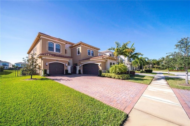 mediterranean / spanish home featuring a garage and a front yard