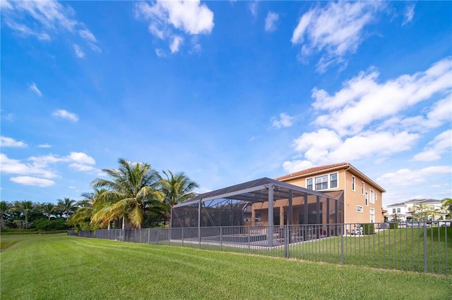 rear view of house featuring a lanai and a yard