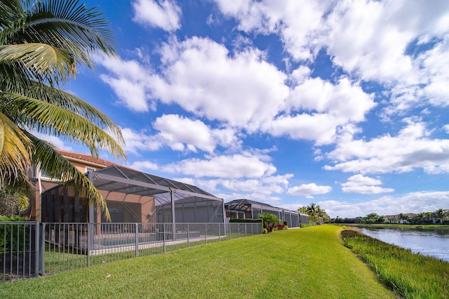 view of yard featuring a water view and glass enclosure