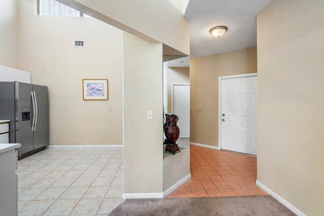 tiled entrance foyer featuring a textured ceiling