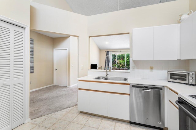 kitchen featuring white cabinetry, sink, stainless steel dishwasher, and light carpet