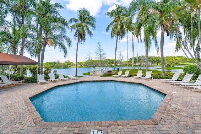 view of swimming pool with a water view and a patio