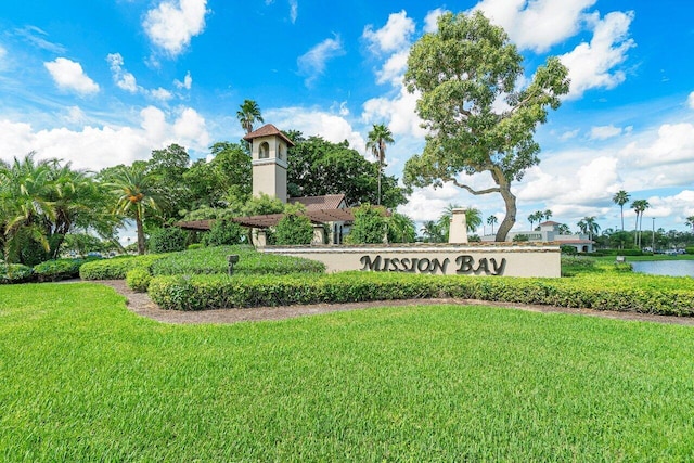 community / neighborhood sign with a water view and a yard