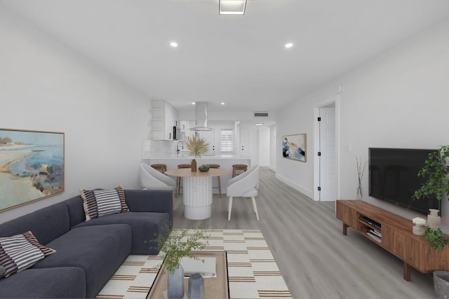 living room featuring sink and light hardwood / wood-style floors