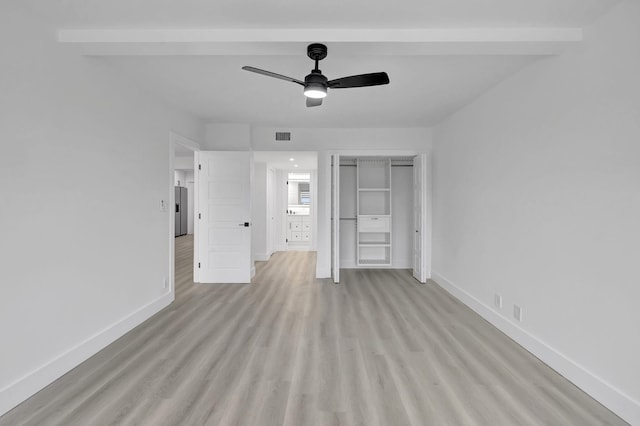 unfurnished bedroom featuring light hardwood / wood-style flooring, stainless steel fridge, ceiling fan, beam ceiling, and a closet