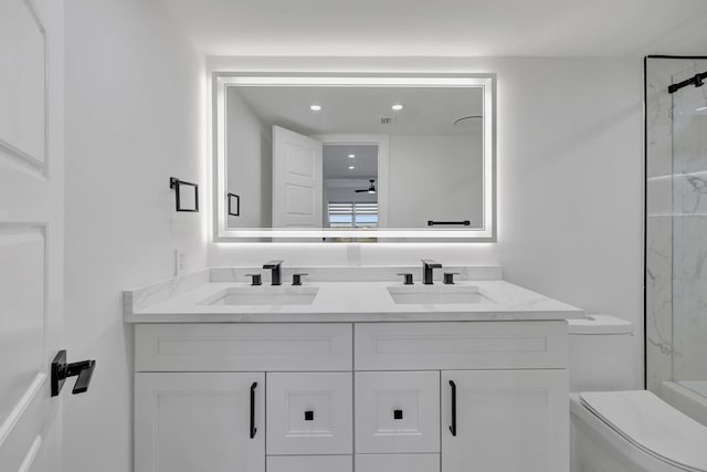 bathroom featuring vanity, toilet, and tiled shower