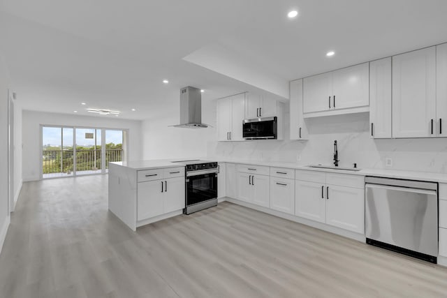 kitchen featuring tasteful backsplash, white cabinets, appliances with stainless steel finishes, range hood, and a sink