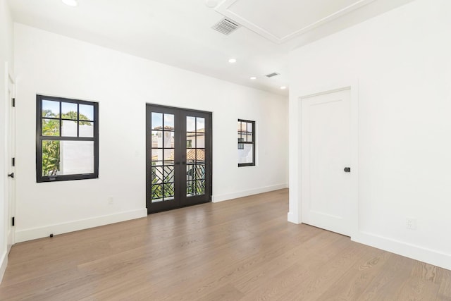 unfurnished room featuring french doors and light wood-type flooring