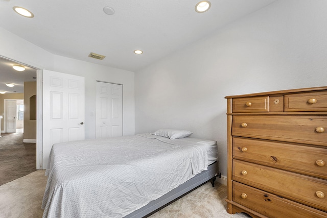 bedroom featuring light colored carpet and a closet