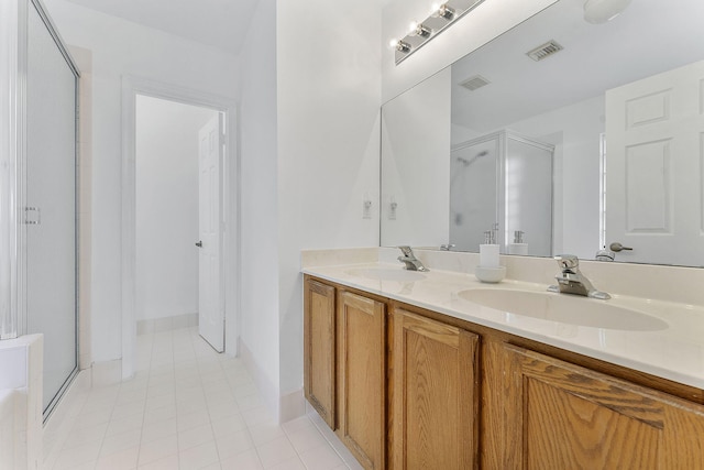 bathroom with tile patterned floors, vanity, and a shower with door