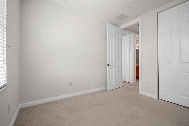 unfurnished bedroom with light colored carpet