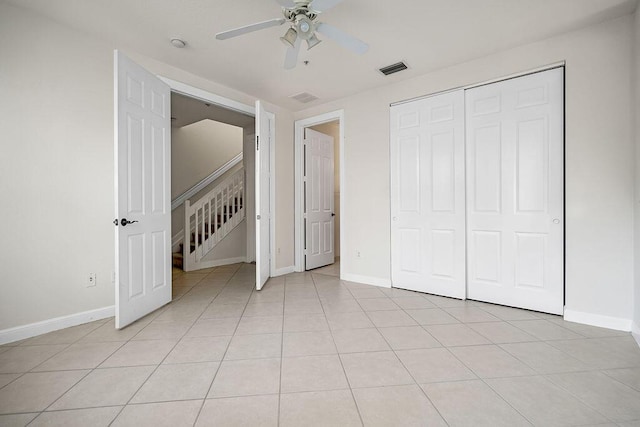 unfurnished bedroom with light tile patterned floors, a closet, and ceiling fan