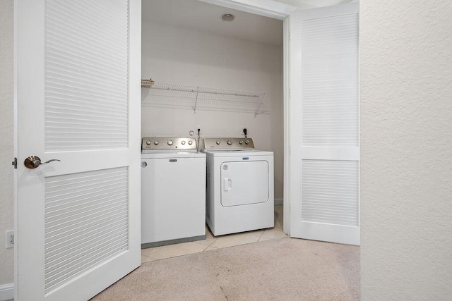 laundry area featuring washer and dryer and light tile patterned floors