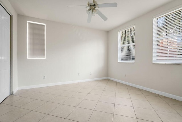 unfurnished room featuring a wealth of natural light, light tile patterned floors, and ceiling fan