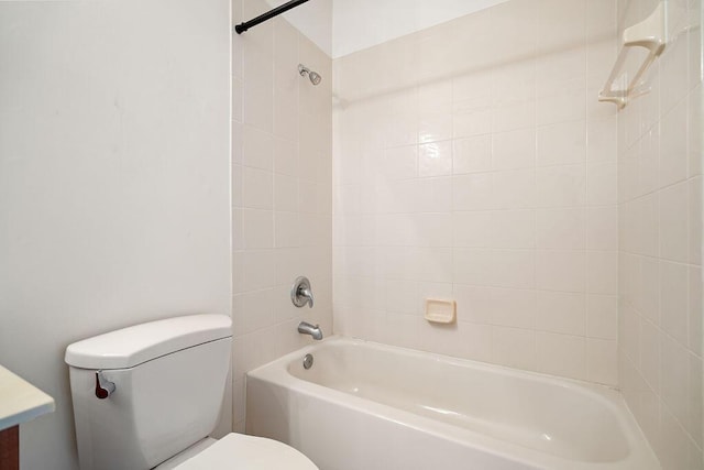 bathroom with tiled shower / bath combo and toilet