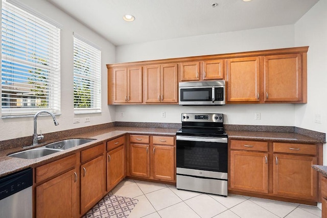 kitchen with light tile patterned floors, stainless steel appliances, and sink