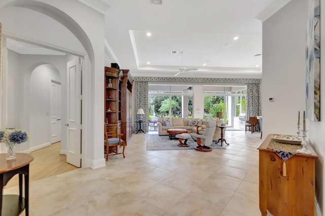 tiled living room with ceiling fan, crown molding, and a tray ceiling