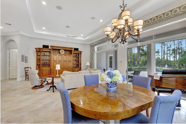 dining room featuring ceiling fan with notable chandelier, a tray ceiling, and crown molding