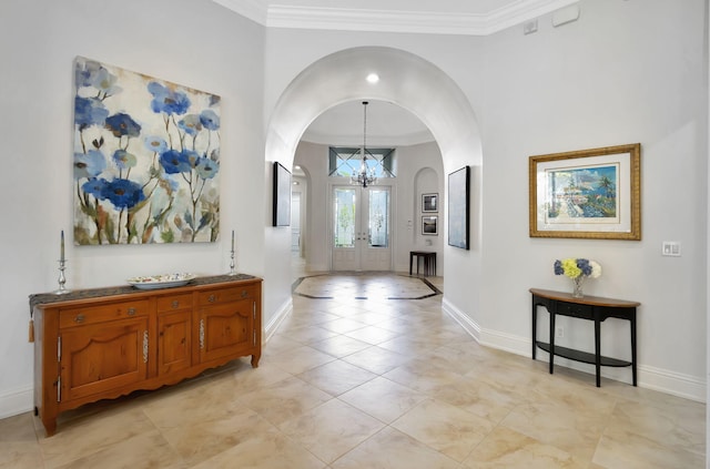 entryway with a chandelier, french doors, and ornamental molding