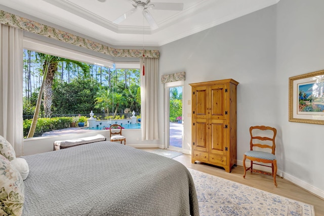 bedroom with ornamental molding, access to outside, a raised ceiling, ceiling fan, and light hardwood / wood-style floors