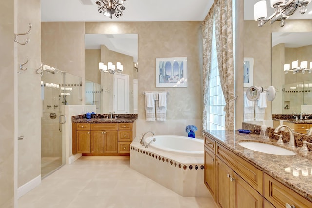 bathroom with tile patterned flooring, vanity, independent shower and bath, and an inviting chandelier