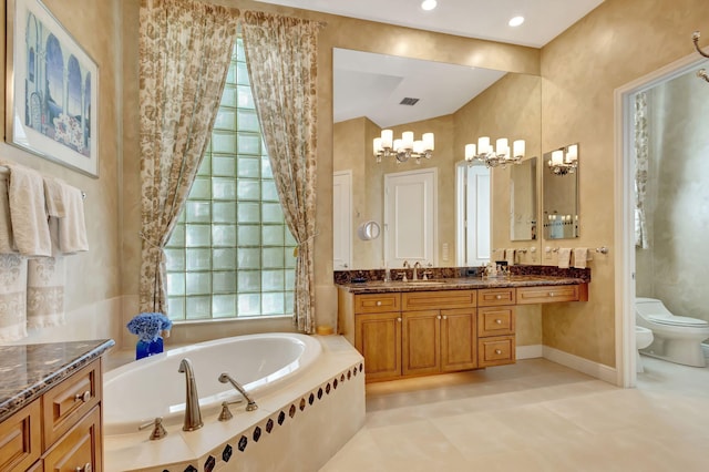 bathroom with vanity, a bidet, toilet, tiled tub, and a chandelier