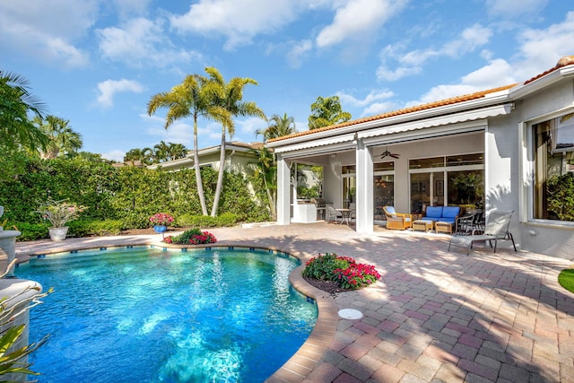 view of pool with outdoor lounge area, a patio, and ceiling fan