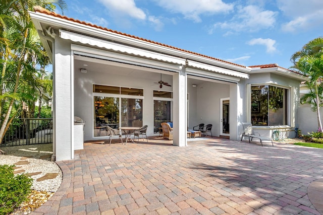 back of house with ceiling fan and a patio