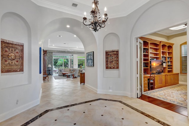 entryway featuring crown molding and a chandelier